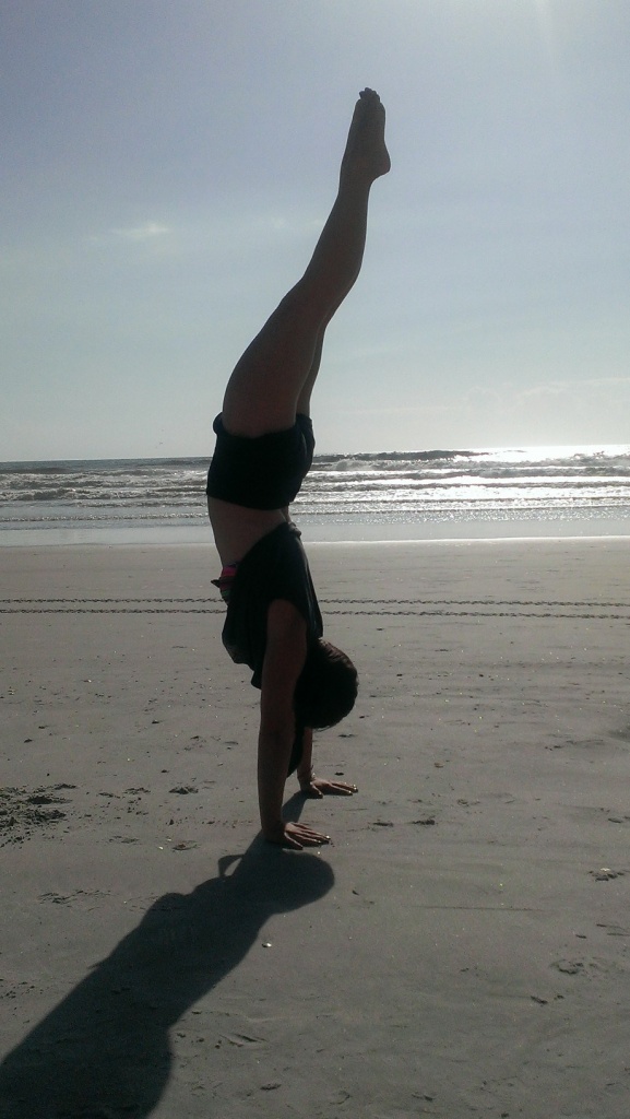 Jenn practicing yoga at the beach. 